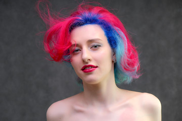 High fashion model woman with multi-colored hair posing in the studio, portrait of a beautiful sexy girl with a fashionable makeup.