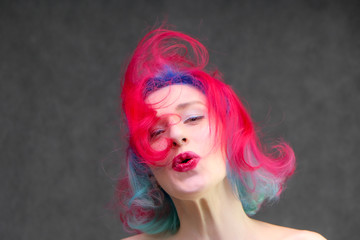 High fashion model woman with multi-colored hair posing in the studio, portrait of a beautiful sexy girl with a fashionable makeup.