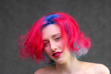 High fashion model woman with multi-colored hair posing in the studio, portrait of a beautiful sexy girl with a fashionable makeup.