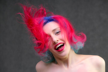 High fashion model woman with multi-colored hair posing in the studio, portrait of a beautiful sexy girl with a fashionable makeup.
