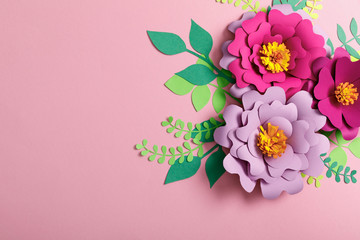 top view of flowers and paper leaves on pink background