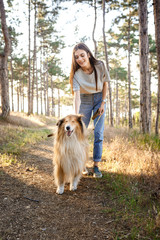 young beautiful woman walking with collie dog.