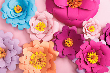 top view of paper colorful flowers on pink background