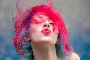 High fashion model woman with multi-colored hair posing in the studio, portrait of a beautiful sexy girl with a fashionable makeup