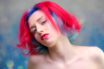 High fashion model woman with multi-colored hair posing in the studio, portrait of a beautiful sexy girl with a fashionable makeup