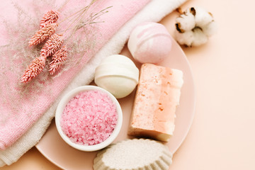 Bath pampering set. Beauty care and relaxation leisure. Assorted cosmetic products on coral pink background.
