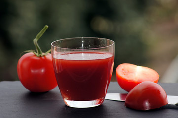 Rote Tomaten mit einem Glas Tomatensaft