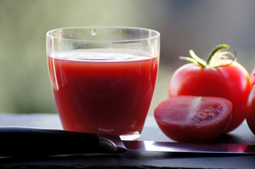 Rote Tomaten mit einem Glas Tomatensaft