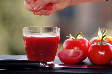 Rote Tomaten mit einem Glas Tomatensaft