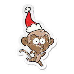 distressed sticker cartoon of a surprised monkey wearing santa hat