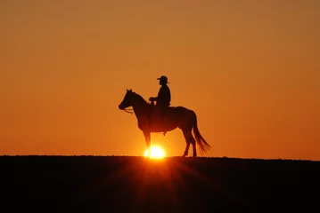 Zelfklevend Fotobehang Cowboy riding horse in the sunset © Myah