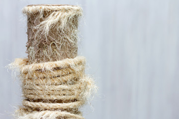 used cat scratching post with torn ropes, copy space