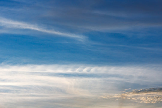 Kelvin, Helmholtz instability clouds wavy on blue sky, feathery curls