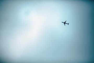 Airplane flies up in the open sky. Blue background