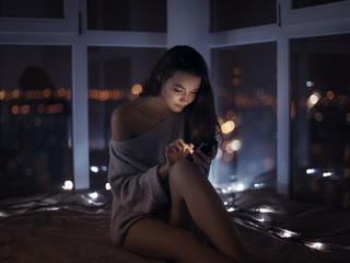 Woman use of mobile phone indoors at night