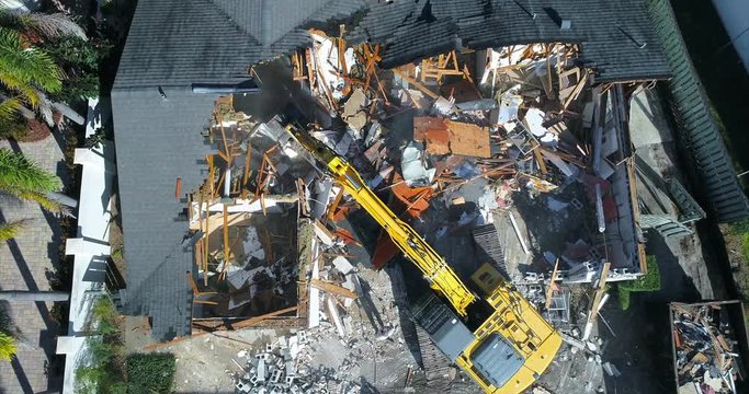 Top-down view of a house demolition with an excavator