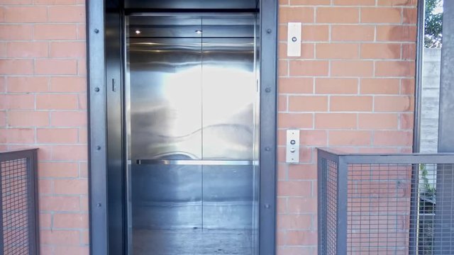 Doors opening and closing on carpark elevator with camera zooming out