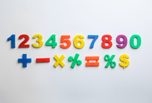 Colorful magnetic numbers and math symbols on white background, top view - Powered by Adobe