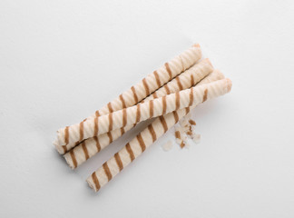Tasty wafer roll sticks on white background, top view. Crispy food