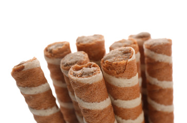 Tasty wafer roll sticks on white background, closeup. Crispy food