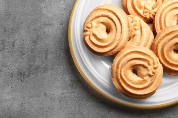 Plate with Danish butter cookies on grey background, top view. Space for text