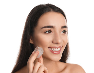 Young woman with ice cube on white background. Skin care