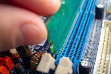 Technician engineer inserts the RAM into the motherboard slot. The concept of high technology and...