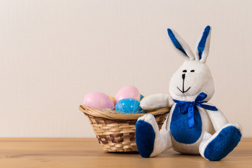 Easter bunny rabbit with  painted egg on wooden background