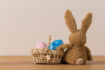 Easter bunny rabbit with  painted egg on wooden background