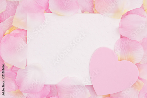 Blank love greeting card on pink rose flower petals