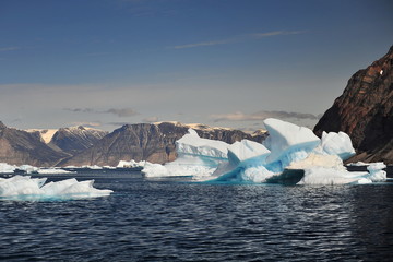 Iceberg, mountains, water, sky.