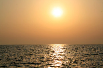Obraz premium Beautiful sunrise cloudscape over sea background. Sun rays beaming through picturesque clouds