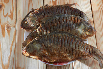 On the kitchen table fried fish in flour, on sunflower oil, has a golden crust and a pleasant smell.