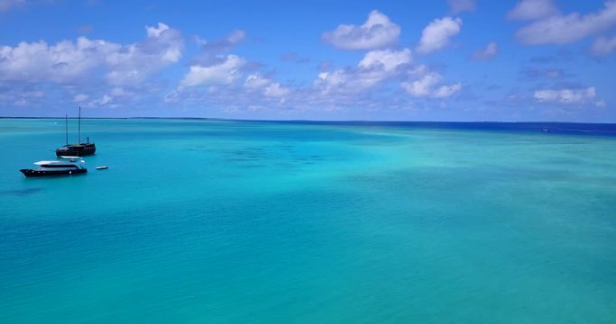 Luxury boats resting in wide endless tropical waters, forward push 4k