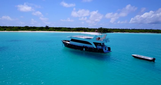 Modern luxury yacht in clear turquoise waters, pan around in 4k