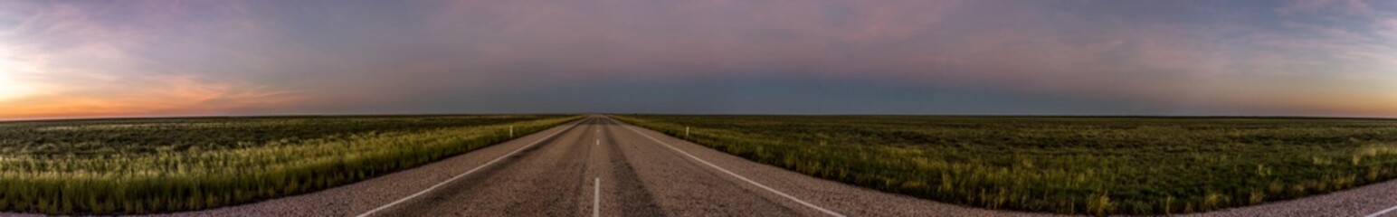 Fototapeta na wymiar panorama of a straight road through the outback of Australia, after a beautiful sunset, Nothern territory