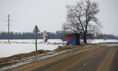 Russian hinterland. bus stop on the road, stella with a sickle and a hammer is a symbol of the...