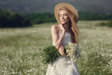 Beautiful woman enjoying field of spring daisy