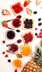 assortment of jams, seasonal berries, plums, mint and fruits in glass jar