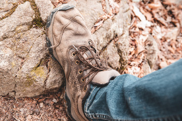 dirty hiking boot with jeans on rock