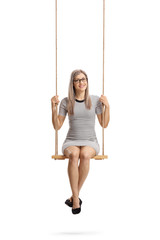 Young cheerful woman sitting on a swing and smiling at the camera