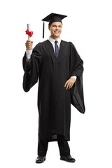 Young man in a black graduation gown and cap holding a diploma