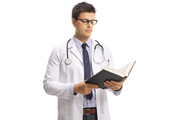 Young male doctor reading a book