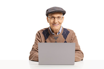 Senior man sitting with a laptop and looking at the camera
