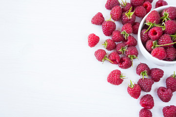 Sprinkled raspberries on white background. Ripe raspberries with copy space for text. Raspberry on a white background. Top view. Various fresh summer fruits. Background of red berries.
