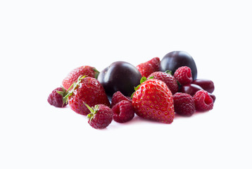 Ripe raspberries, strawberries, red berries and plums on white background. Background of mix fruits with copy space for text. Mix berries isolated on white background. Various fresh summer. 