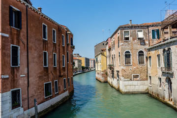 Fototapeta na wymiar Italy, Venice, Hotel Pantalon, CANAL AMIDST BUILDINGS AGAINST CLEAR SKY