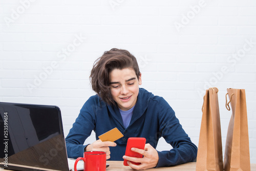 young man with credit card and laptop buying online