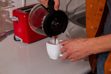 Guy pours coffee in a mug