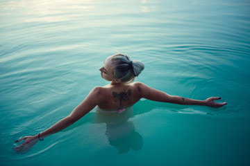 beautiful and young woman at sunset in the lake